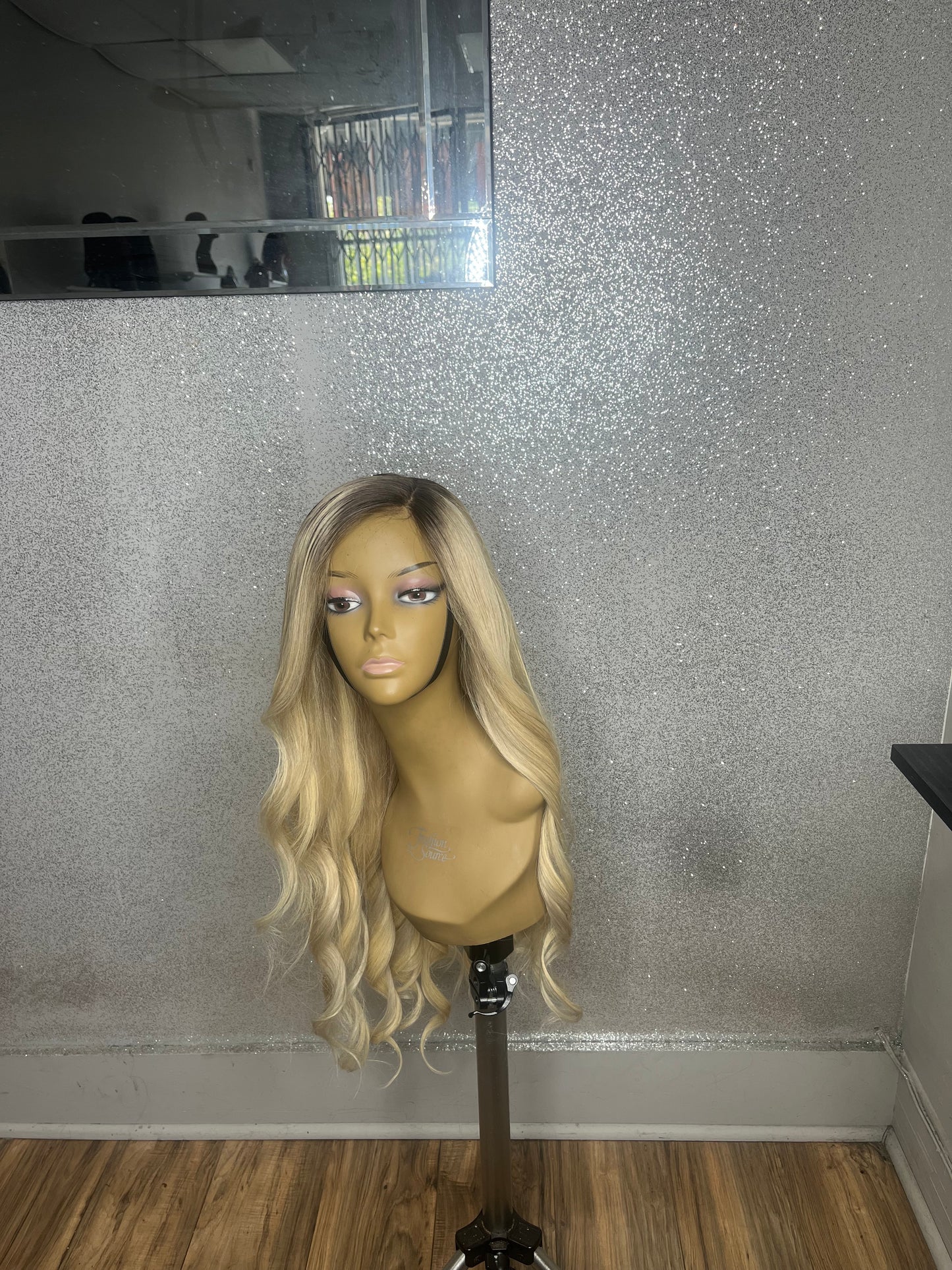Mannequin head with blonde wig on a gray floor